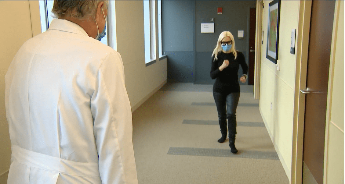 woman walking down hallway in doctors office